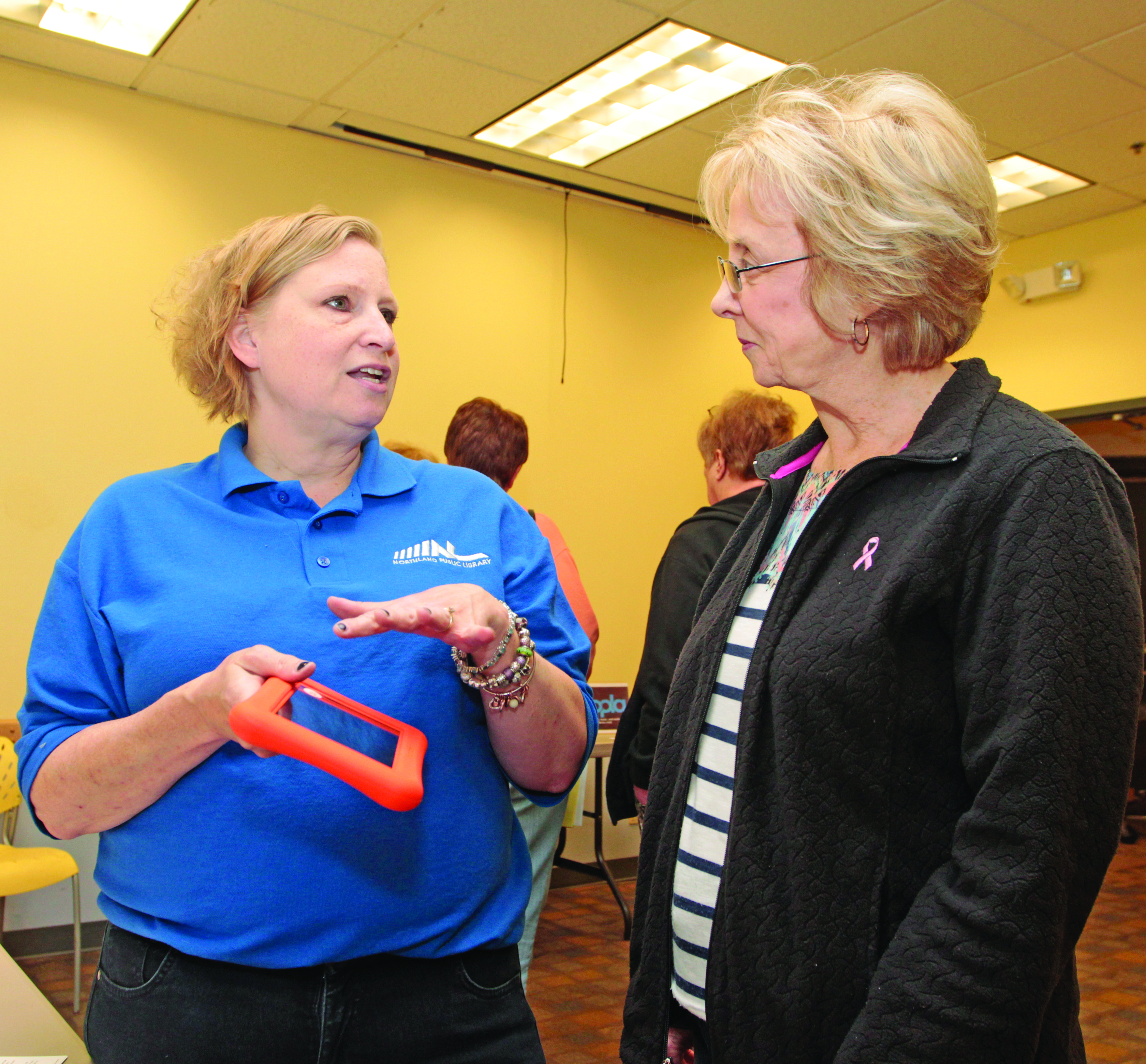 Children’s librarian Jeanne Bondi explains the benefits of the “Playaway” device to Connie Johnston. Photo by Chuck LeClaire